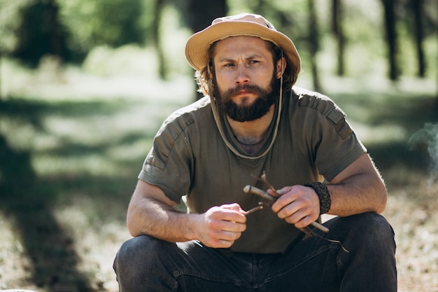 Turista dal falò nella foresta