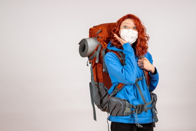 Turista femminile di vista frontale che va in viaggio di montagna con lo zaino