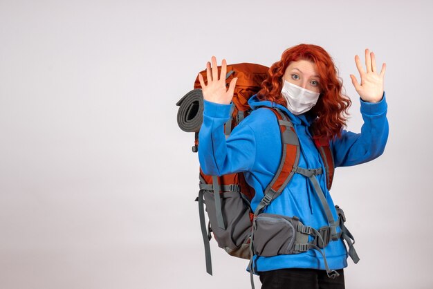 Turista femminile di vista frontale che va in viaggio di montagna con lo zaino