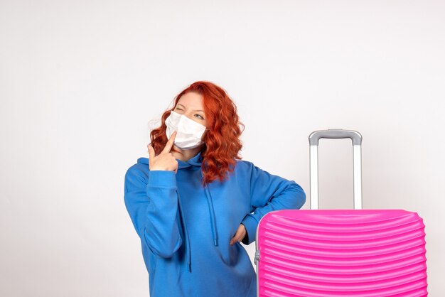 Turista femminile di vista frontale con borsa rosa nel pensiero della maschera