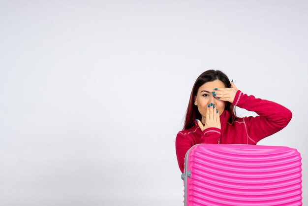 Turista femminile di vista frontale con la borsa rosa sul viaggio di emozione di viaggio di colore di vacanza dei voli della città della donna della parete bianca