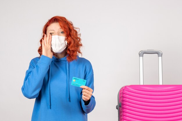 Turista femminile di vista frontale nella maschera che tiene carta di credito