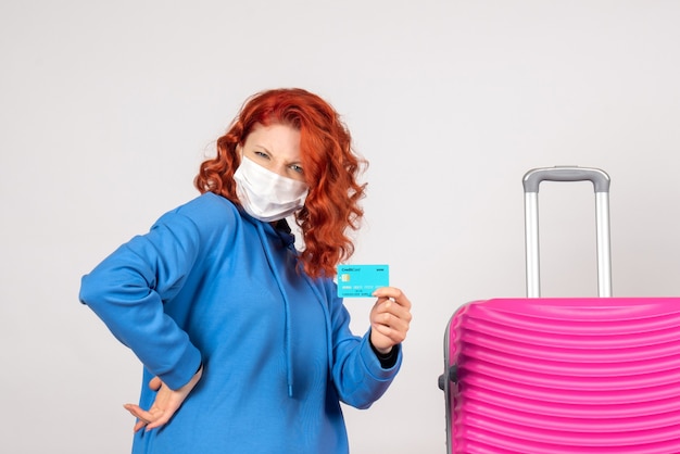 Turista femminile di vista frontale nella maschera che tiene carta di credito