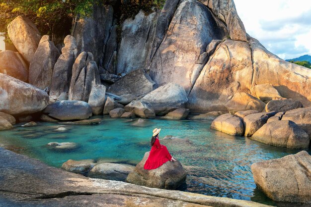 Turista seduto sulla roccia vicino al nonno e al nonno rock Hin Ta e Hin Yai Rocks sulla spiaggia di Lamai Koh Samui Thailandia