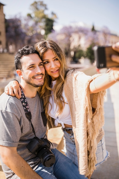 Turista sorridente che prende autoritratto sul telefono cellulare