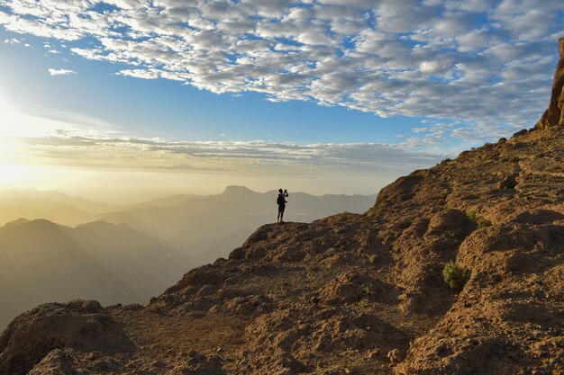 Turista sulla cima di una montagna rocciosa a Gran Canaria, Spain