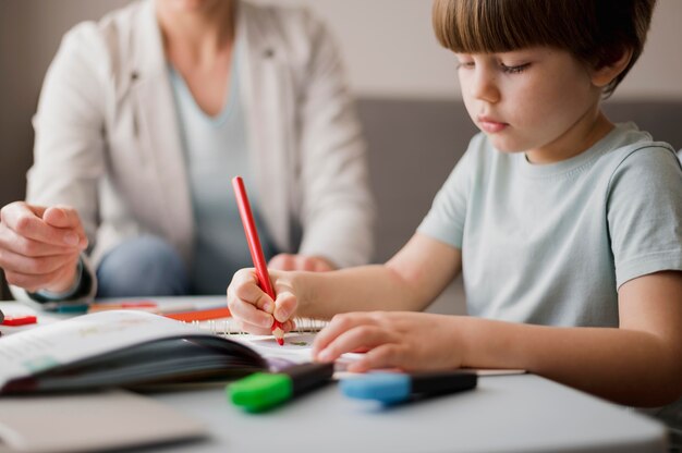 Tutor che insegna al bambino a casa