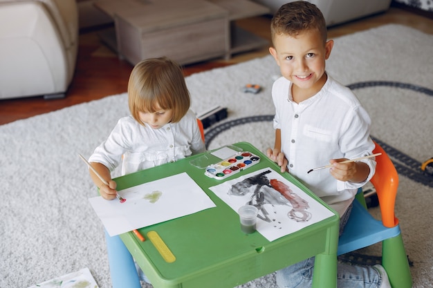 Ubicazione dei bambini al tavolo verde e disegno