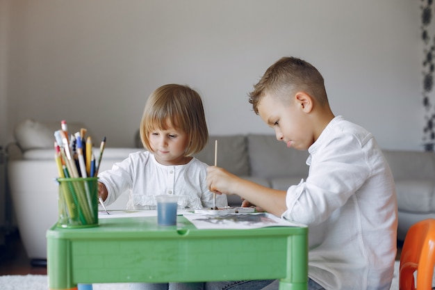 Ubicazione dei bambini al tavolo verde e disegno