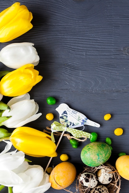 Uccello carino vicino a tulipani e uova