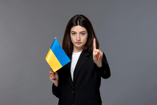 Ucraina conflitto russo carino giovane donna dai capelli scuri in giacca nera che dice di fermarsi con la bandiera