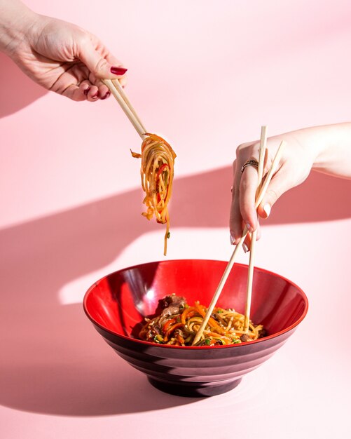 udon mescolare le tagliatelle fritte con salsa di soia e peperoni di peperone di carne in una ciotola