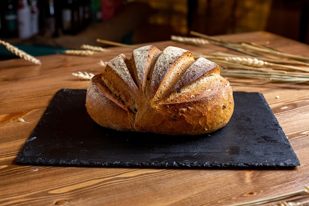 Un appetito saporito del forno al forno intero del pane bianco di vista frontale sulla pasta di pasticceria isolata tessuto nero