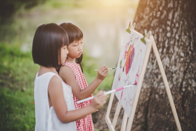 Un&#39;arte di due pittore della bambina che assorbe il parco