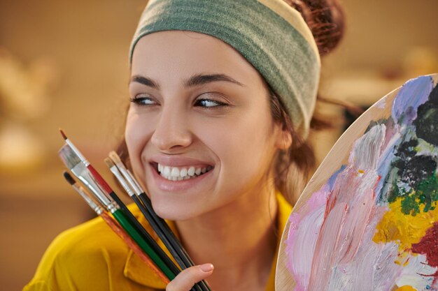 Un'artista femminile carina che sembra felice e soddisfatta.