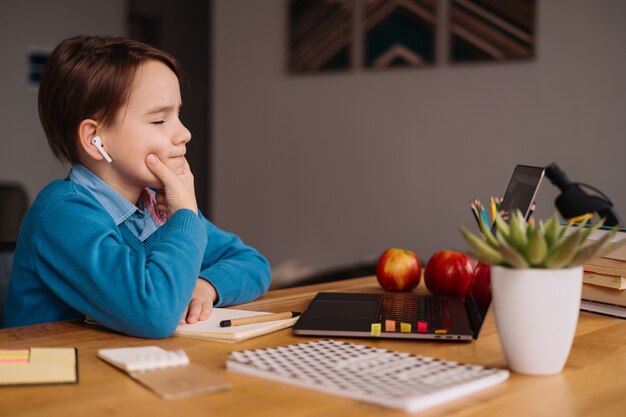 Un bambino preteen usa un laptop per fare lezioni online