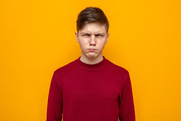 Un bel ragazzo sospettoso che indossa un maglione rosso