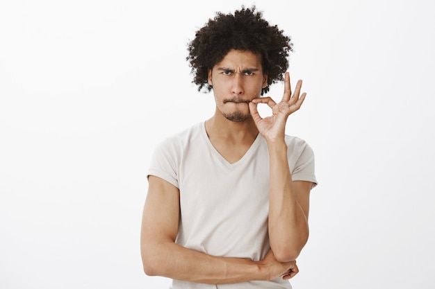 Un bell'uomo serio promette di non parlare, chiudendo la bocca sul sigillo