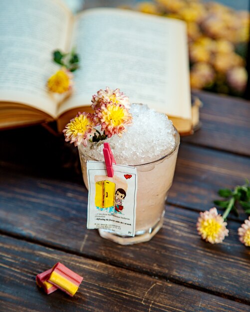 Un bicchiere di bevanda con ghiaccio decorato con fiori e liner dall'amore isgum