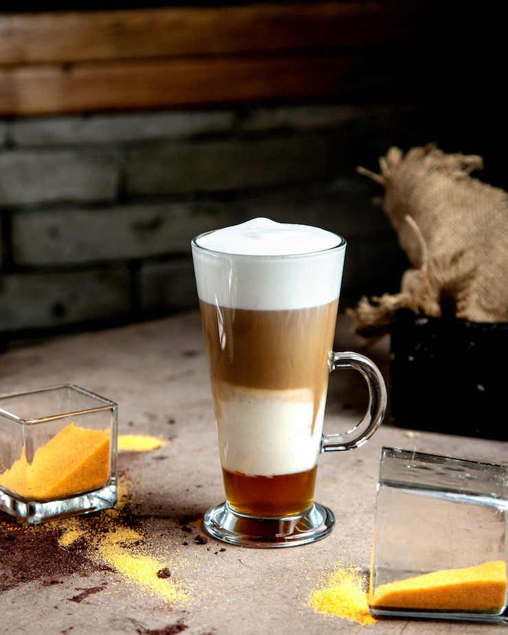 Foto gratuito un bicchiere di caffè a tre strati con panna e sciroppo