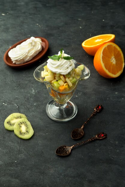 Un bicchiere di frutta mista con panna