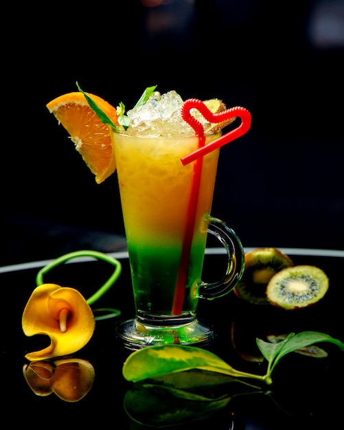 Un bicchiere di kiwi e arancia cocktail guarnito con fetta d'arancia e kiwi