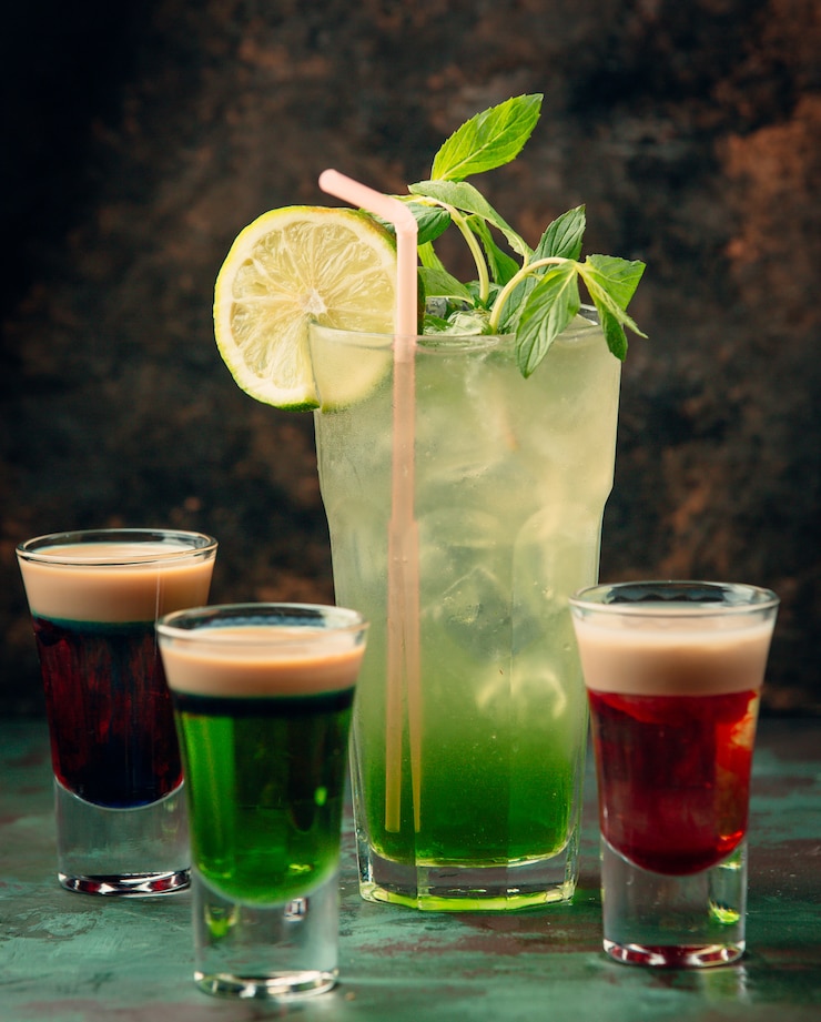 Foto gratuito un bicchiere di mojito con tre colpi colorati intorno