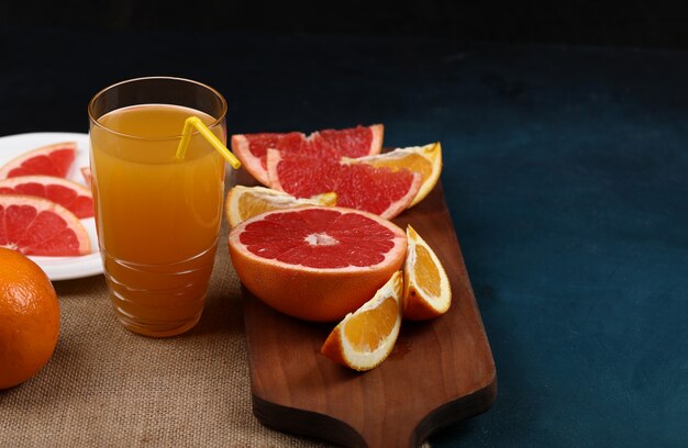 Un bicchiere di succo d'arancia con frutta a fette.