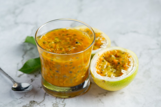 un bicchiere di succo di frutto della passione posto sul pavimento di marmo bianco