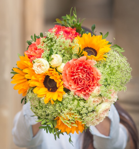 Un bouquet di fiori rosa e girasoli gialli con foglie verdi