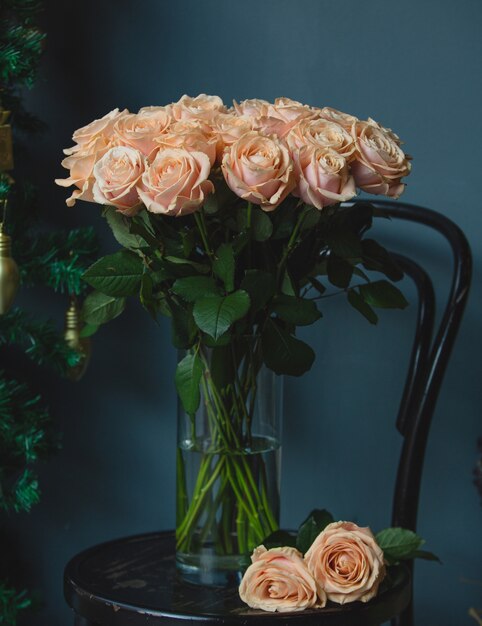 Un bouquet di rose rosa con foglie verdi all'interno di un vaso