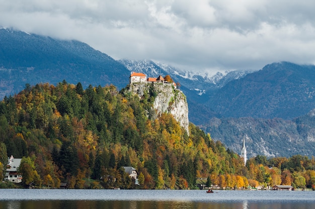Un castello storico sulla cima di una collina coperta di foglie colorate a Bled, Slovenia