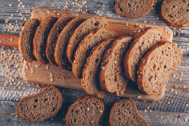 Un certo pane affettato su un tagliere su superficie di legno, vista dall'alto