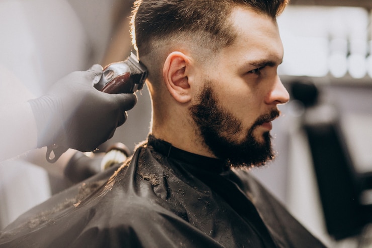 Foto gratuito un cliente che si taglia i capelli in un barbiere.