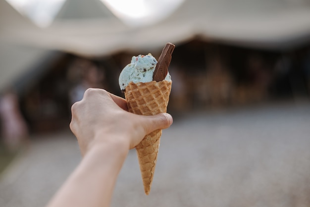 Un cono gelato con pallina di gelato al gusto blu con una fetta di cioccolato