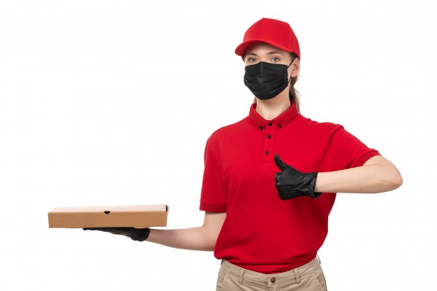 Un corriere femminile di vista frontale in guanti rossi della camicia rossa della camicia rossa e scatole nere della pizza della tenuta della maschera su bianco