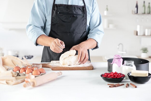 Un cuoco con uova su una cucina rustica contro le mani degli uomini