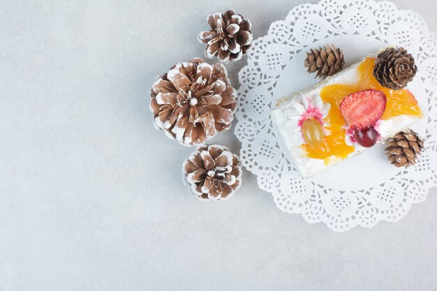 Un delizioso pezzo di torta con pigne su sfondo bianco. Foto di alta qualità