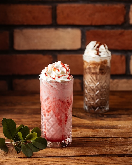 Un dessert alla crema di vista frontale con fragole e cioccolato sulla frutta del gelato del dessert dello scrittorio di legno