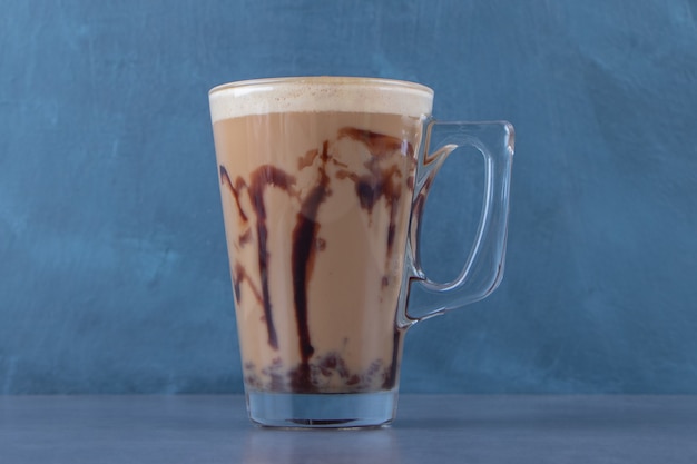 Un display di cappuccino al cioccolato, sullo sfondo blu. Foto di alta qualità