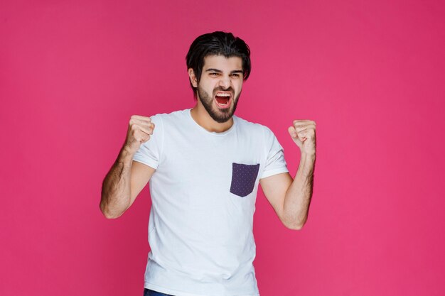 Un fan che mostra il suo pugno e i muscoli mentre la sua squadra ha vinto.