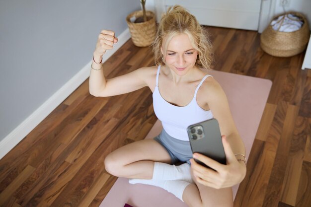 Un giovane allenatore di fitness, un istruttore di yoga, fa un live stream, si fa dei selfie sullo smartphone mentre