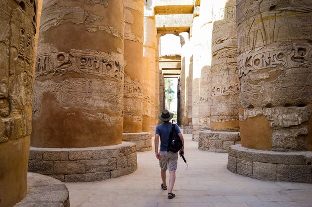 Un giovane che cammina in un tempio egizio