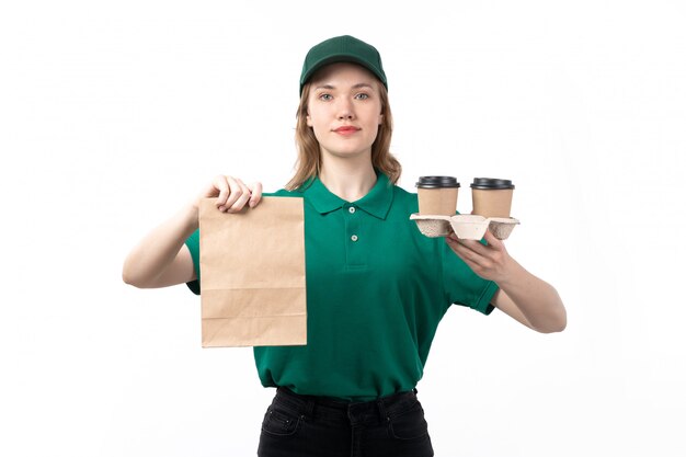 Un giovane corriere femminile di vista frontale in pacchetto dell'alimento e tazze di caffè sorridenti uniformi verdi della tenuta