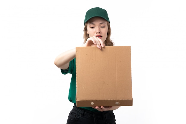 Un giovane corriere femminile di vista frontale in pacchetto sorridente della tenuta dell'uniforme verde con alimento che lo apre
