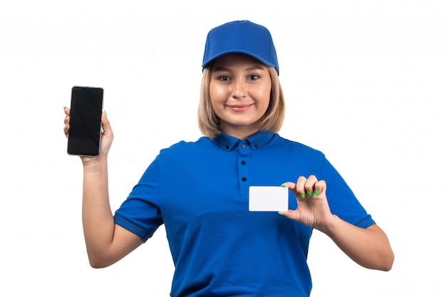 Un giovane corriere femminile di vista frontale in telefono uniforme blu della tenuta e carta bianca