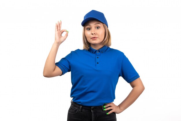 Un giovane corriere femminile di vista frontale in uniforme blu che posa appena