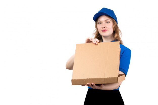 Un giovane corriere femminile di vista frontale nel sorridere uniforme del pacchetto di consegna della tenuta