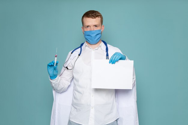 Un giovane di vista frontale in camicia bianca e guanti blu con maschera blu sullo spazio blu