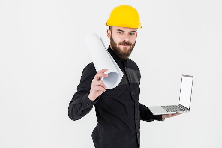 Foto gratuito un giovane ingegnere che tiene il modello di rolledup e apre il computer portatile contro il contesto bianco